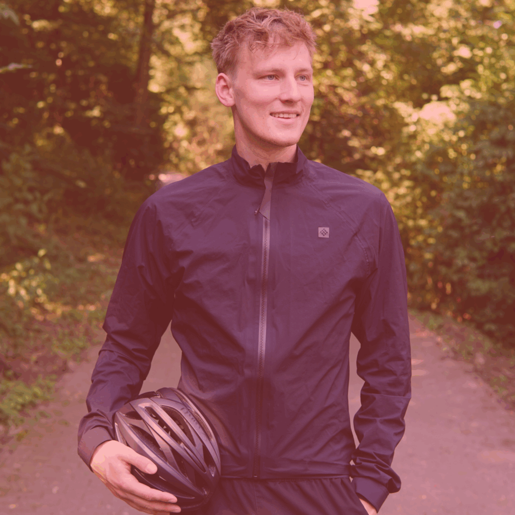Fabian Abel aus Köln erzählt im achten Interview von seiner schwersten Etappe: Der Radtour durch die Sahara. Auf dem Foto trägt Fabian eine blaue Windjacke und hat den Fahrradhelm in seiner rechten Hand. Die Linke hat steckt in seiner Hosentasche. Fabian schaut nach rechts und lächelt. Das Foto unterliegt dem Copyright von Fabian Abel